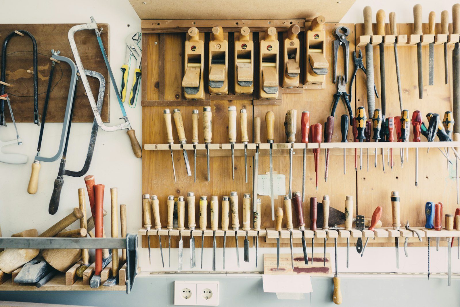 Assorted handheld tools hanging in a metal rack